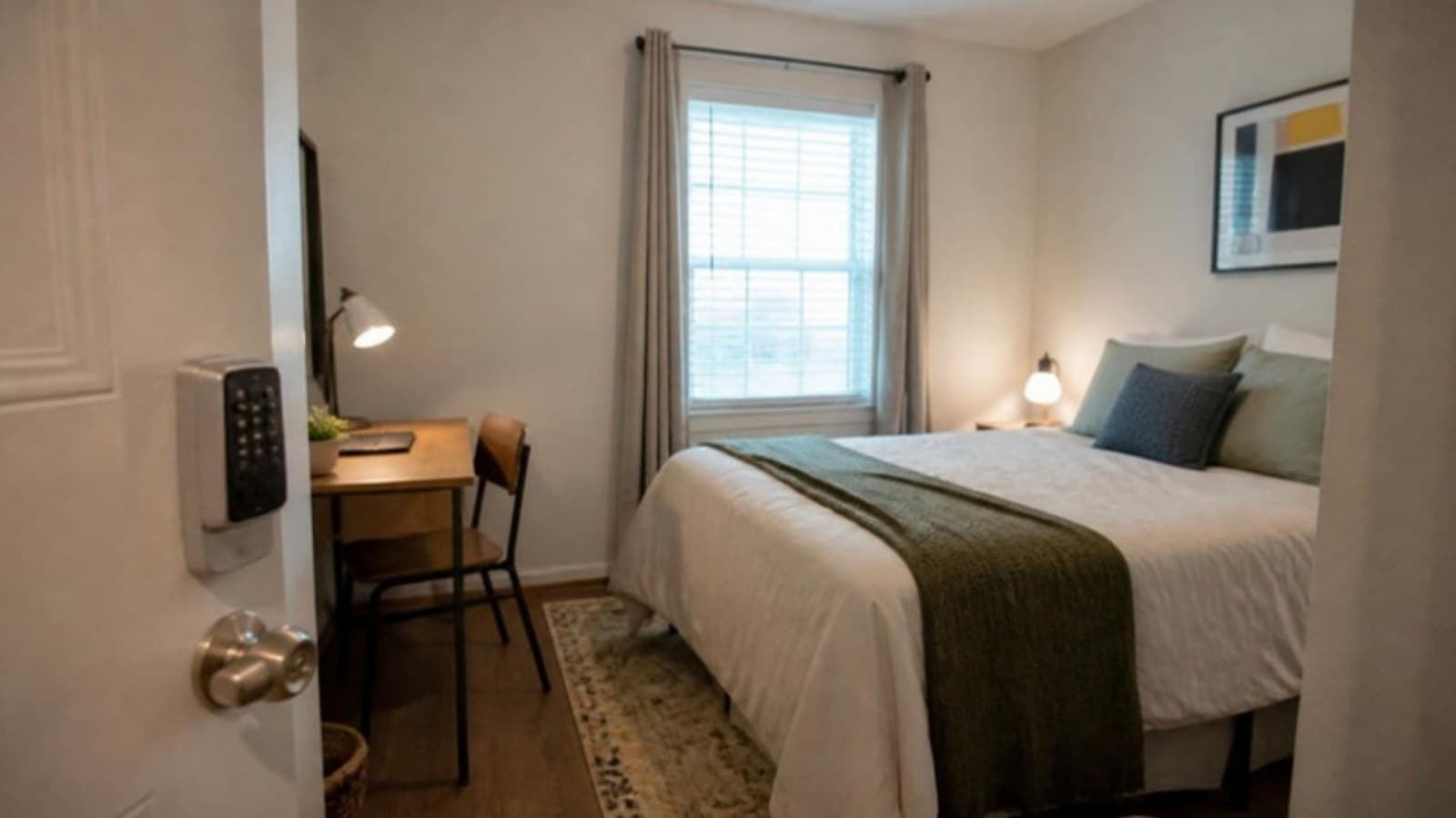Furnished private bedroom with a keypad lock on the door in a shared home, for a guide to house hacking by renting rooms